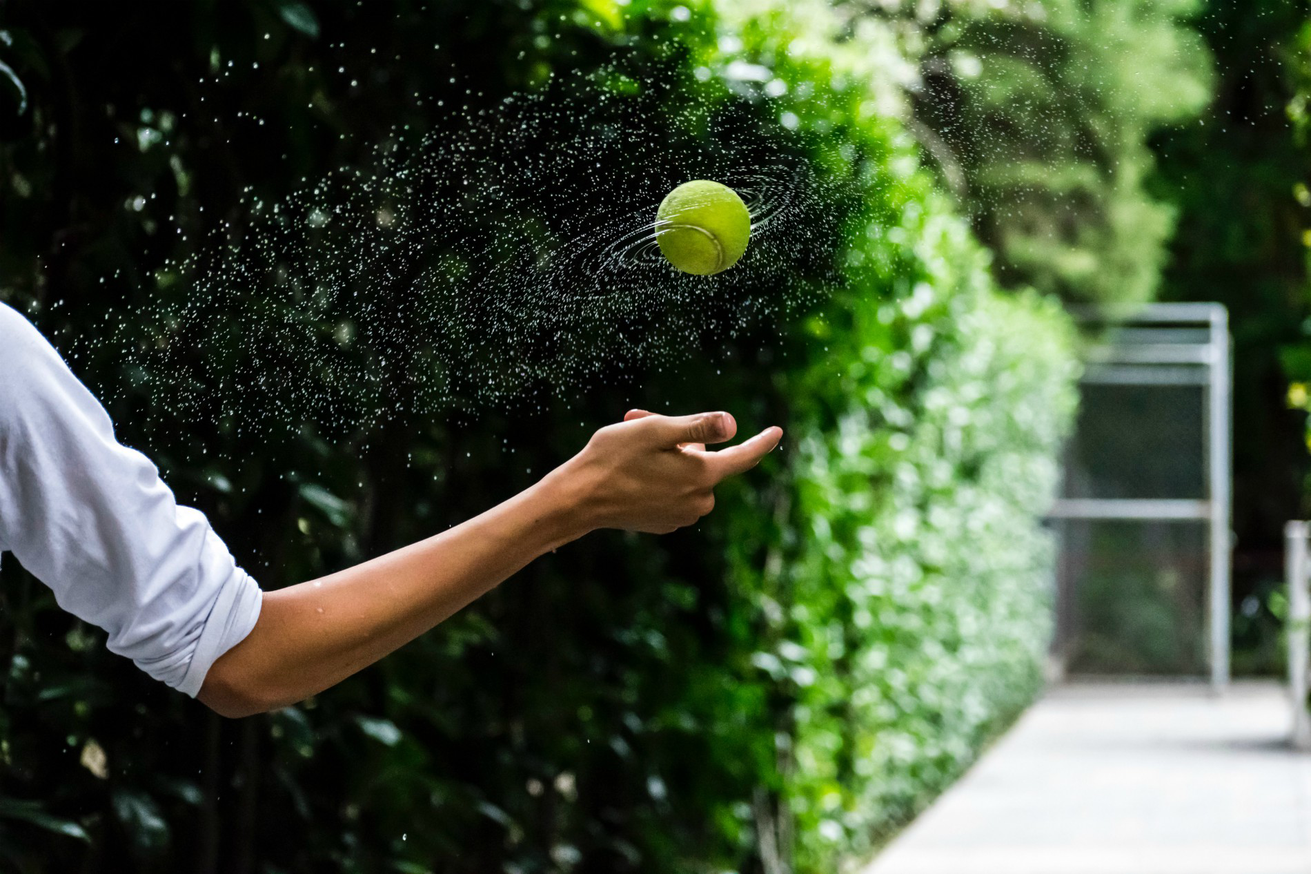 Wheaton Sport Center person spinning wet tennis ball in air