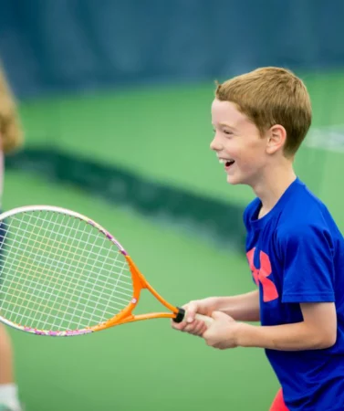 Wheaton Sport Center child smiling during tennis lesson