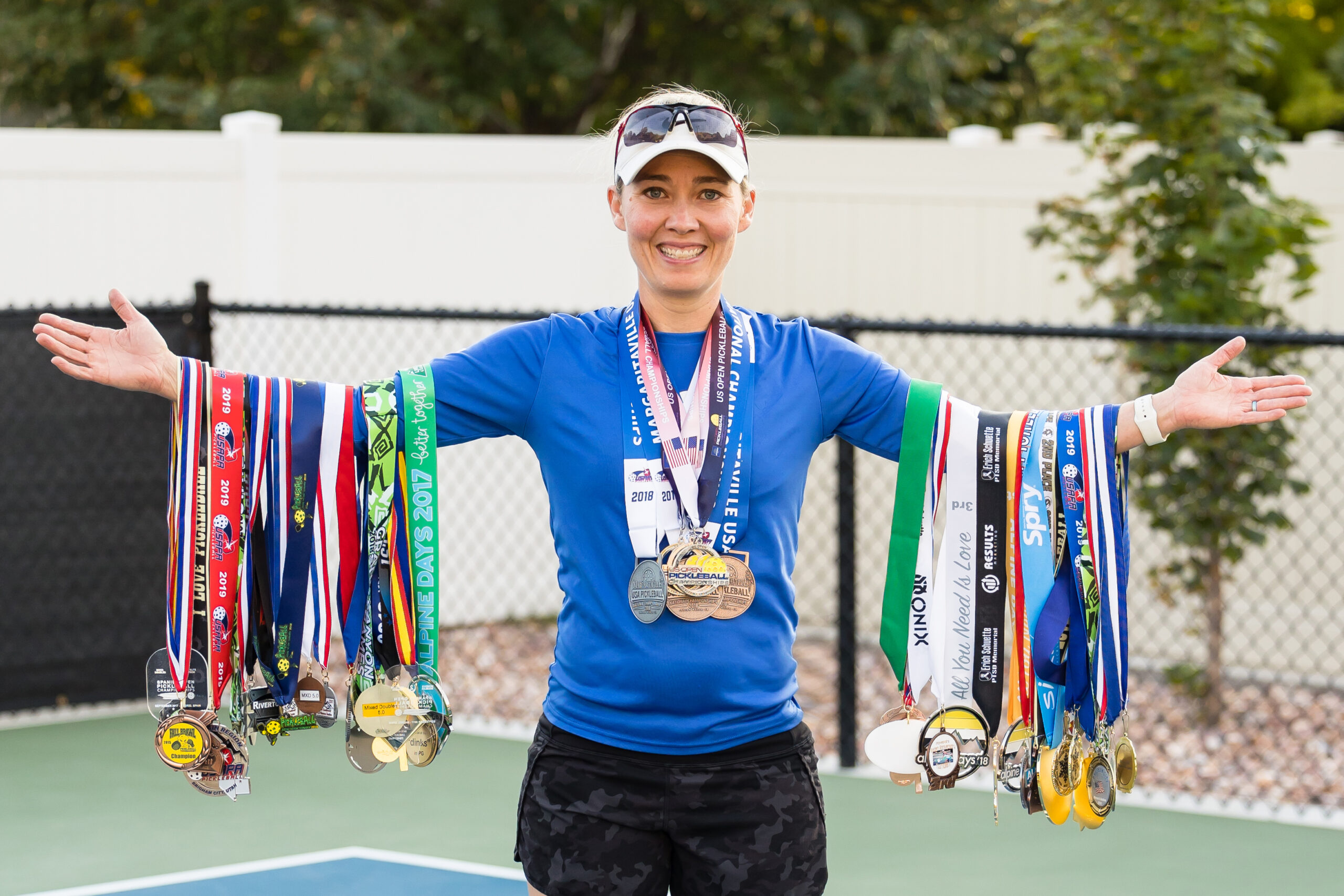 Suzee Anderson playing pickleball, holding all her medals
